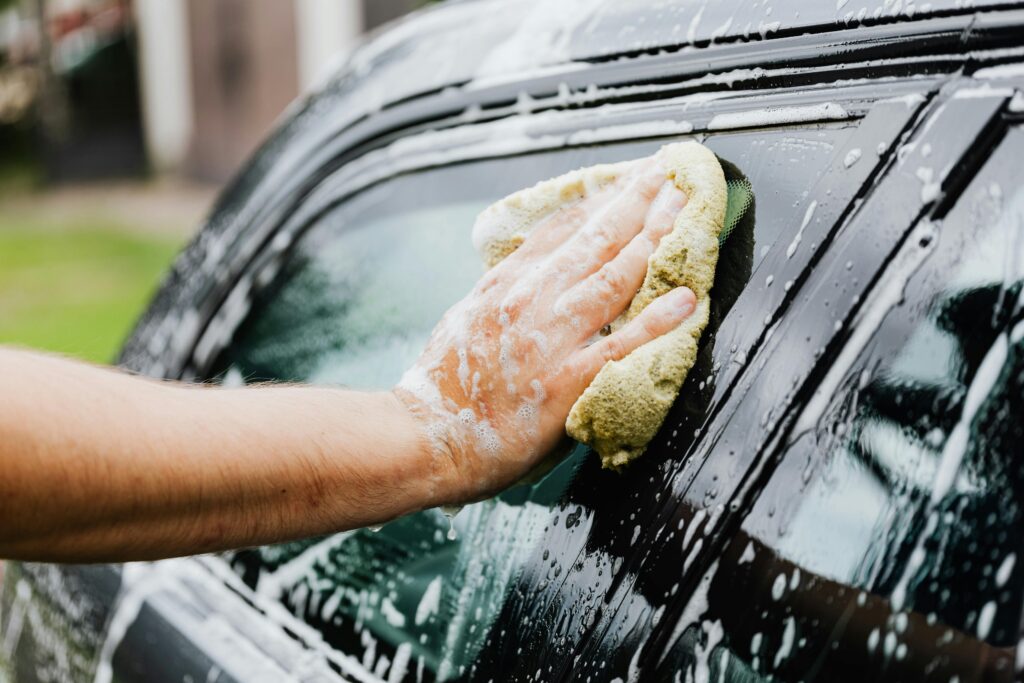 Car side glass being cleaning with soap