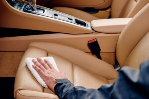 Person using a cloth to wipe a car seat- interior detailing