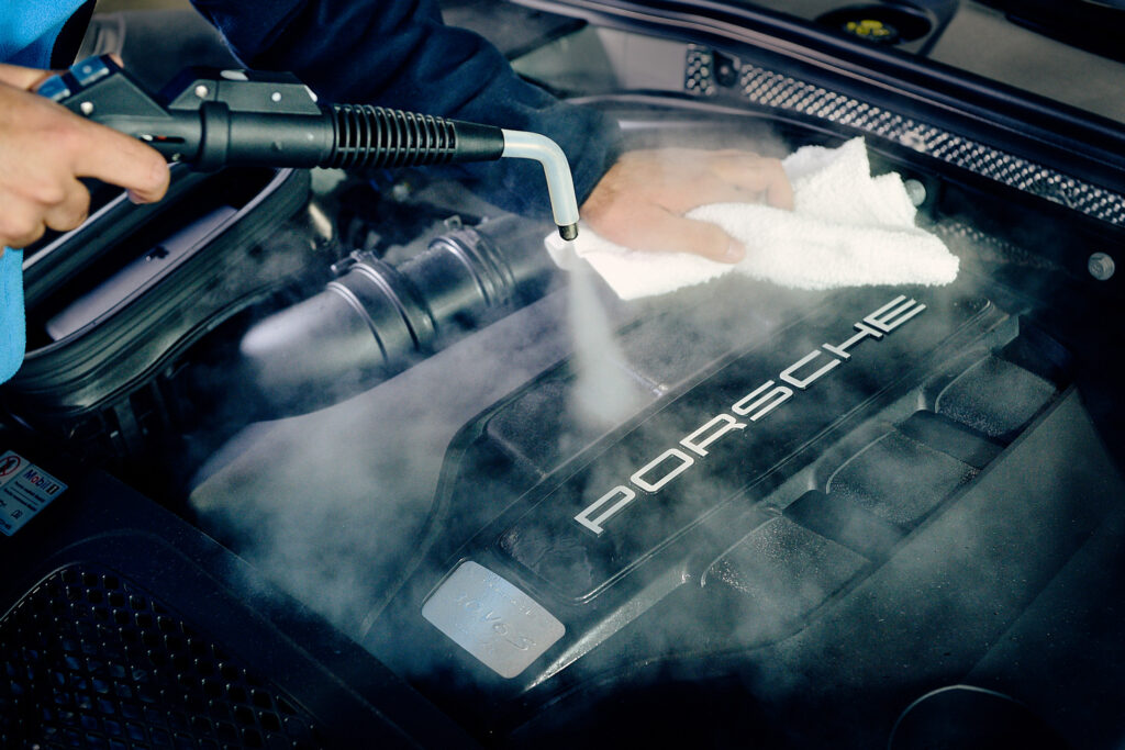 Someone cleaning the engine of a car