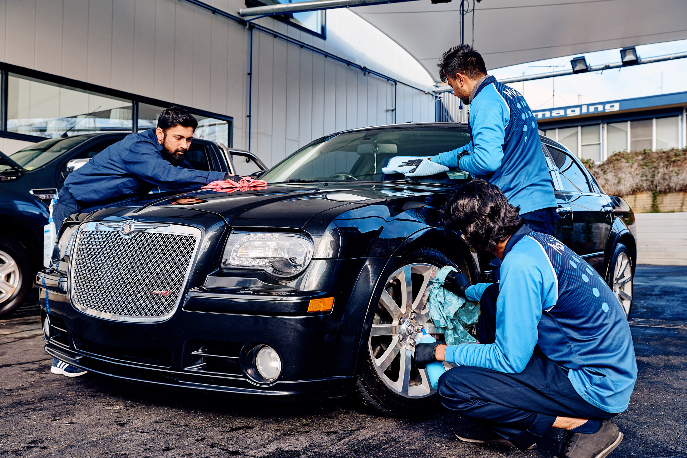 Car cleaning by three people at the best car wash service with Magic Hand Car Wash