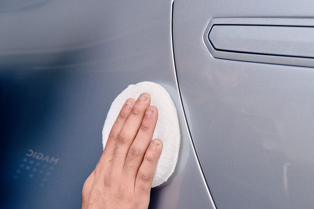 car is getting hand waxed for shiny and protected from sun in Australian sun