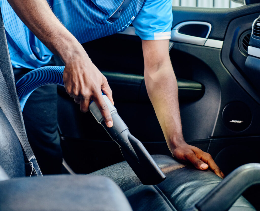 car wash attendant steam cleaning a car