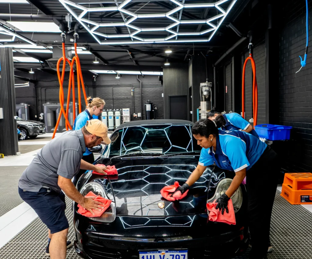magic hand carwash team cleaning a black Porche at the store in Joondalup